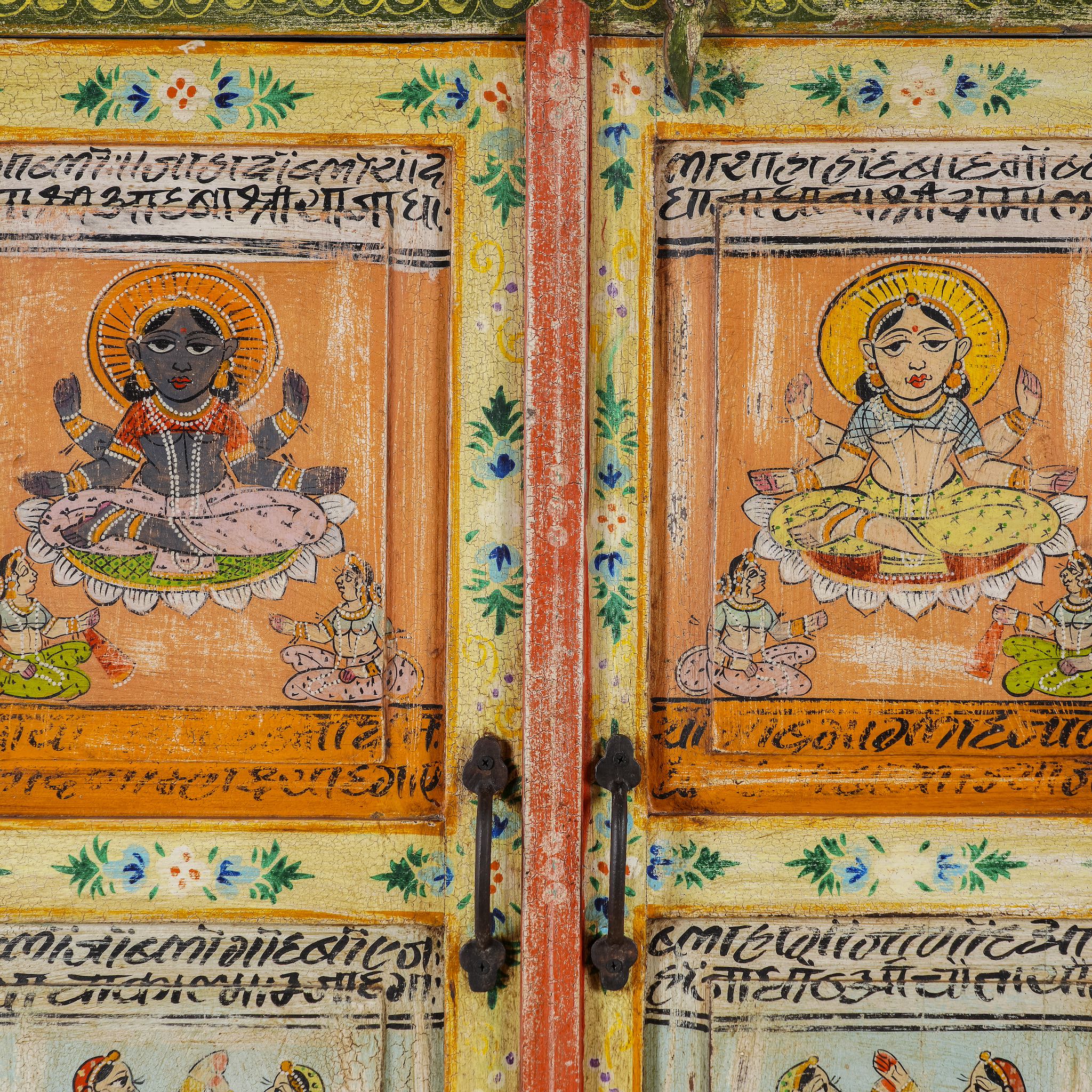 Close up image of a hand painted reclaimed wood furniture cabinet with Indian god motifs, vintage furniture with cultural detailing, 90 × 40 × 150 cm.