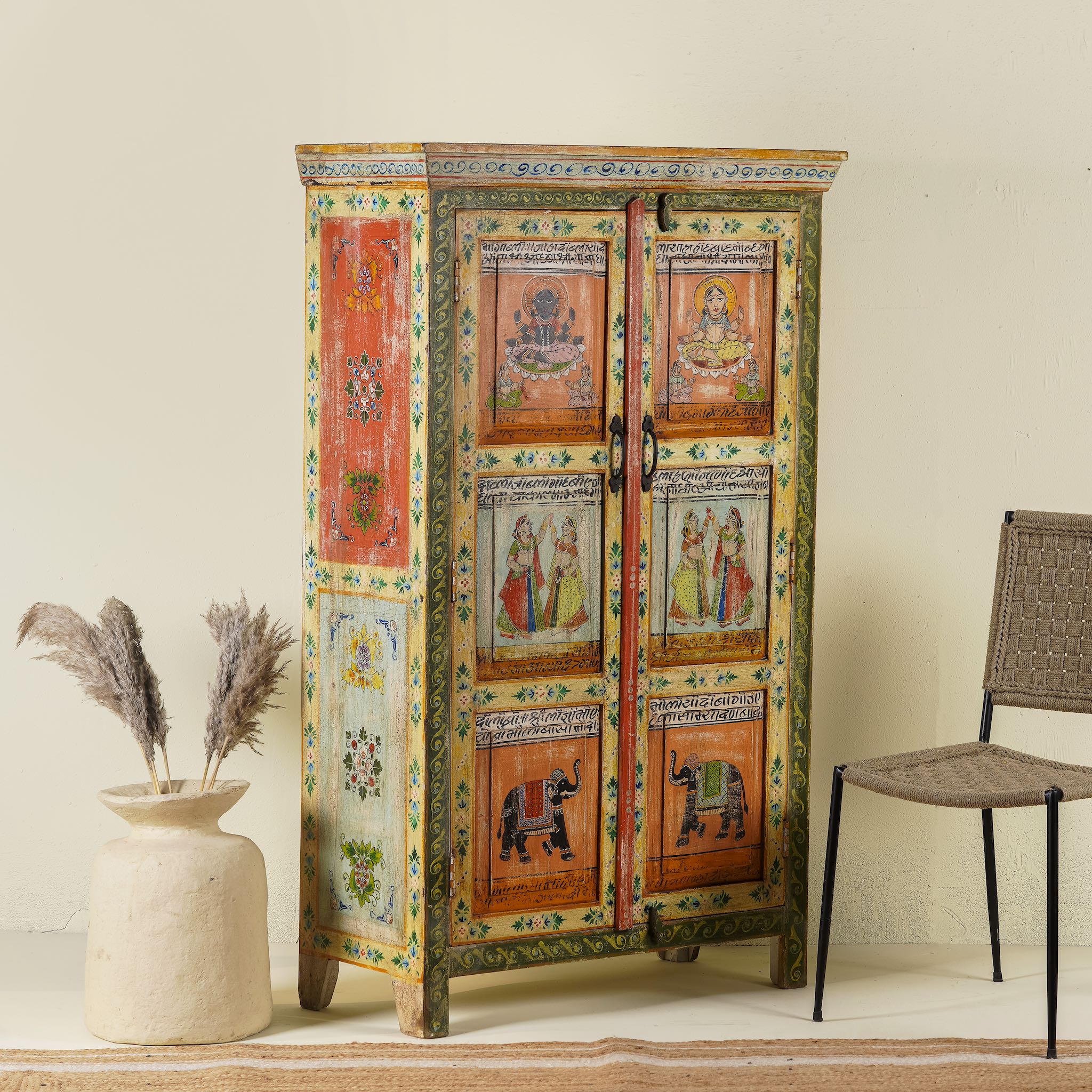 Side angle image of a hand painted reclaimed wood furniture cabinet with Indian god motifs, vintage furniture with cultural detailing, 90 × 40 × 150 cm.