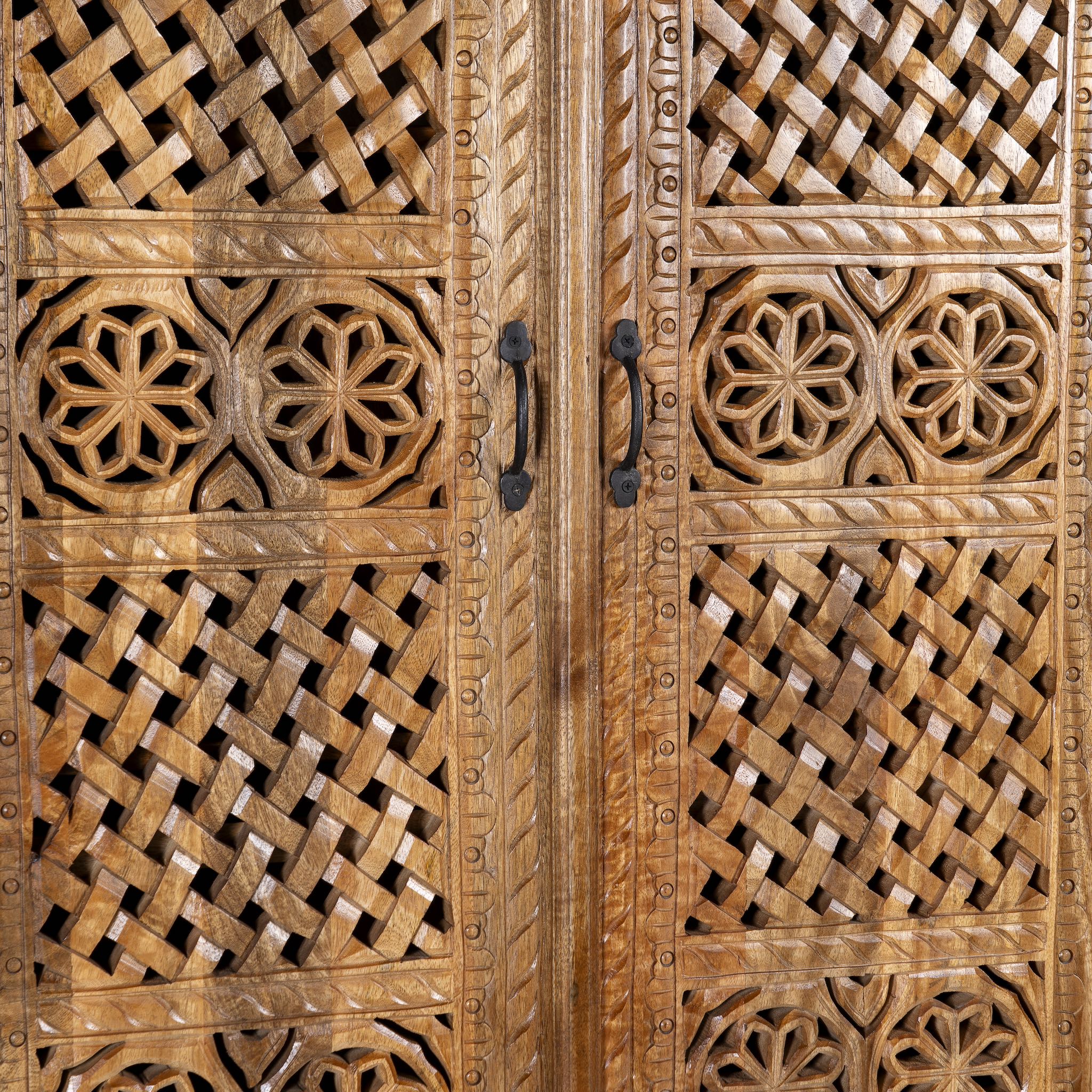 Close up image of a hand-carved mango wood wardrobe with floral and lattice motifs – a detailed piece of carved wood furniture ideal for natural mango wood interiors.