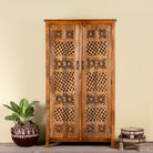 Hand-carved mango wood wardrobe with floral and lattice motifs – a detailed piece of carved wood furniture ideal for natural mango wood interiors.