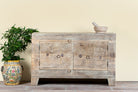 Handcrafted sideboard Tanay made from reclaimed teak wood, featuring antique Indian door fronts with original carvings. A Mediterranean-inspired piece of unique Indian furniture with sustainable character and functional storage.