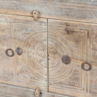 Close up image of a handcrafted sideboard Tanay made from reclaimed teak wood, featuring antique Indian door fronts with original carvings. A Mediterranean-inspired piece of unique Indian furniture with sustainable character and functional storage.