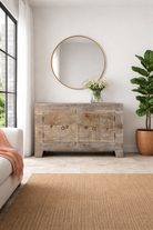 Lifestyle imagination o a handcrafted sideboard Tanay made from reclaimed teak wood, featuring antique Indian door fronts with original carvings. A Mediterranean-inspired piece of unique Indian furniture with sustainable character and functional storage.