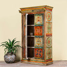 Side angle image of a hand-painted teak wood cabinet with floral motifs; teak wood furniture for bohemian interiors, 105 × 55 × 177 cm.