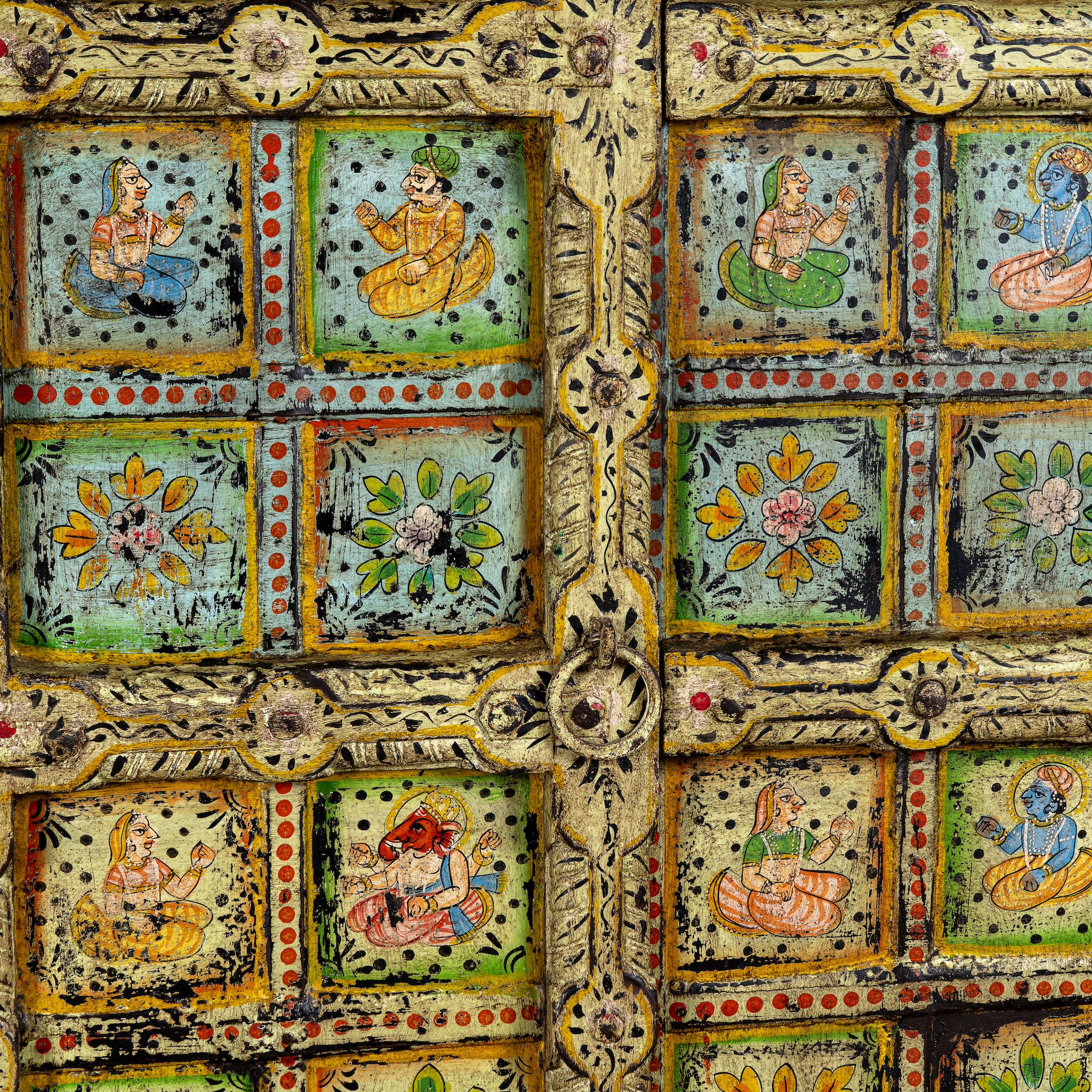 Close up image of a hand painted wardrobe made of teak wood with floral motifs; unique furniture inspired by Indian artistry, 104 × 50 × 186 cm.