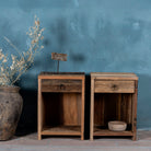 Front view image of a pair of bedside tables in Driftwood/ Wabi Sabi style crafted from recycled old wood, each featuring a single drawer with a metal ring pull and an open shelf below, showcasing natural wood grain and rustic textures.


