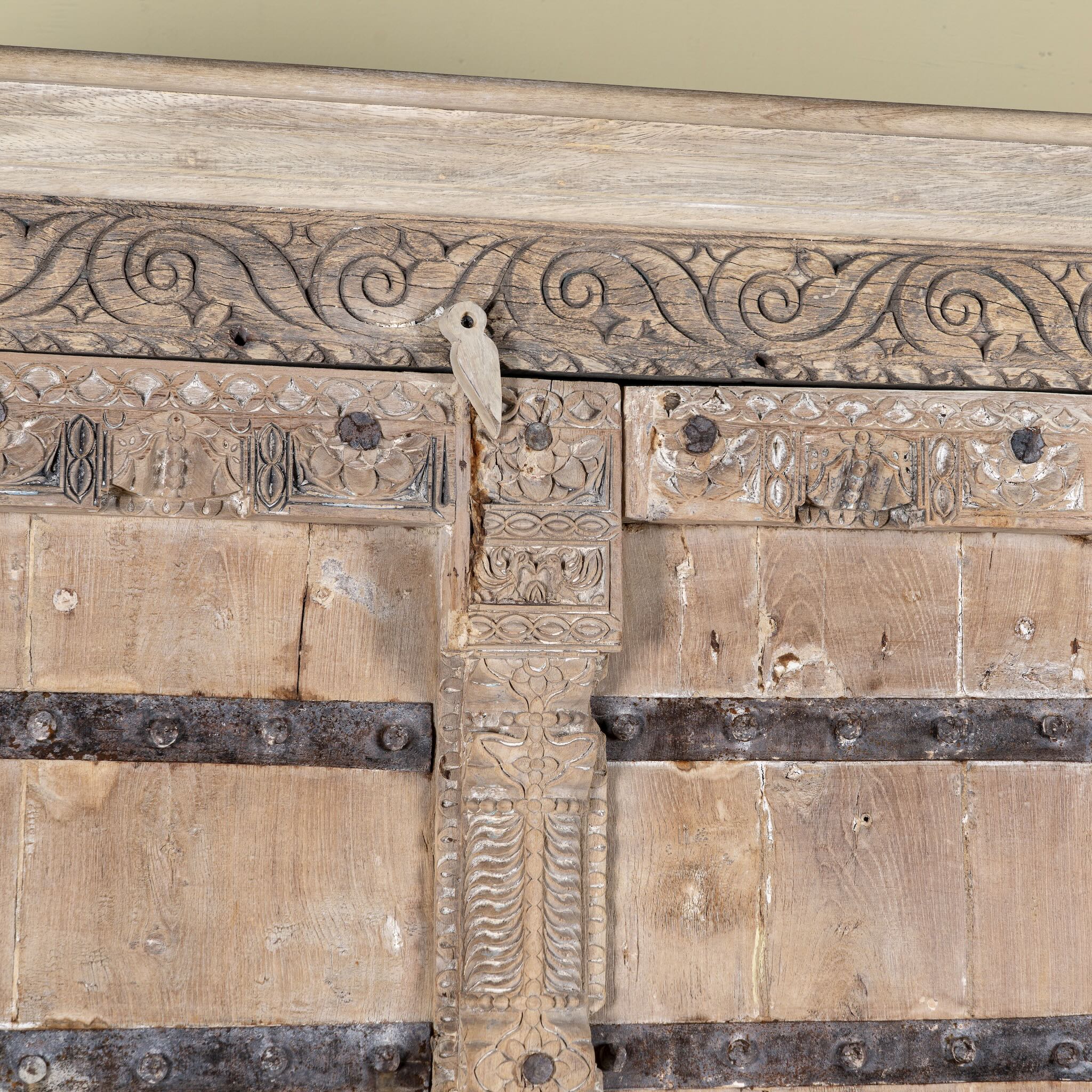 Close up image of a hand-carved teak wood wardrobe with original iron fittings – Veena model by Om Home & Garden