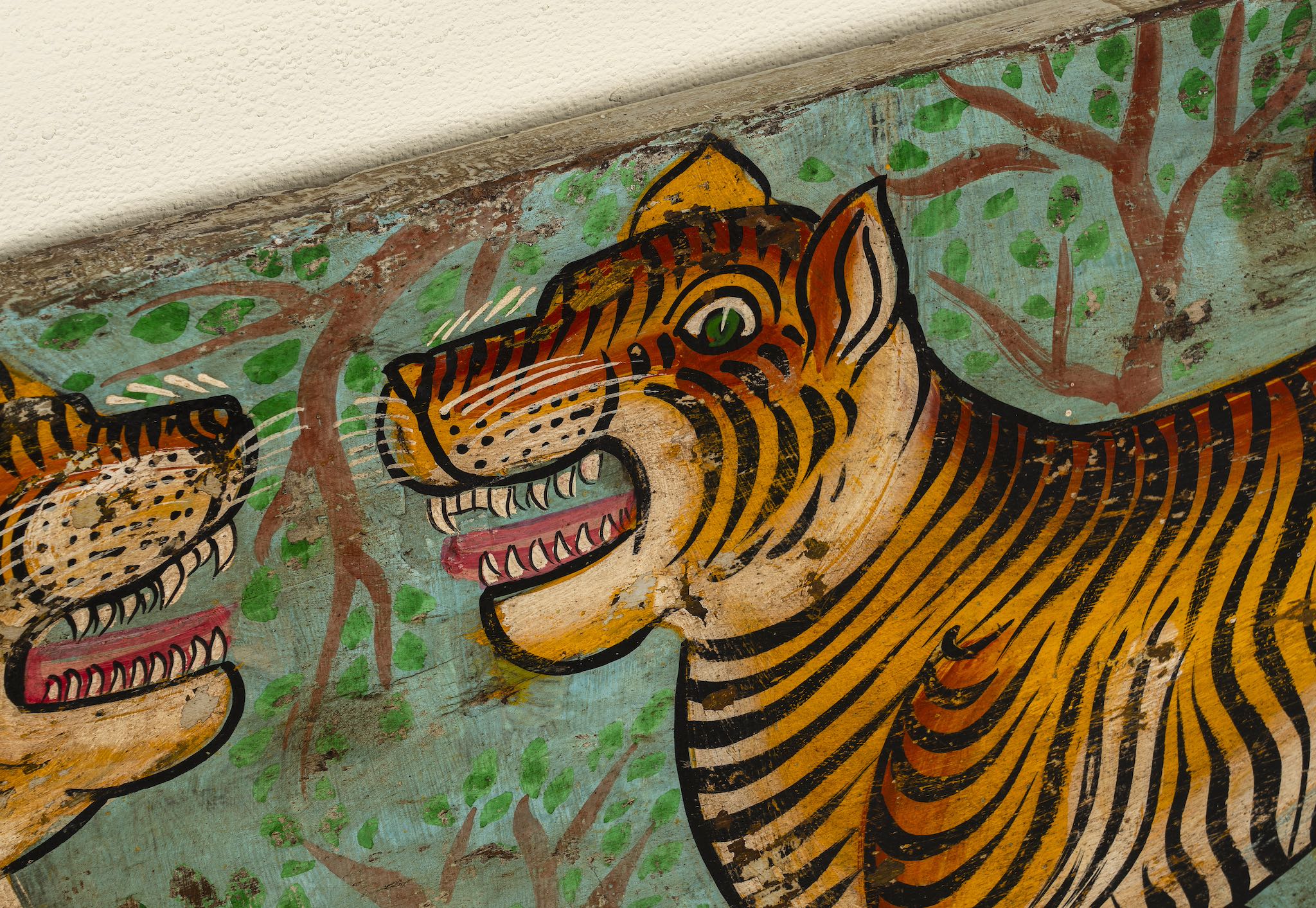 Close up image of a Virat hand painted wall panel featuring a vibrant tiger motif on reclaimed antique teak wood—an artisan-crafted tiger wall decoration blending history and bold artistry.