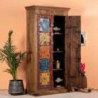 Side angle image with open door of a hand-painted cabinet made from reclaimed teak wood with colourful Indian motifs – sustainable furniture and vintage teak wood craftsmanship for bold interiors.