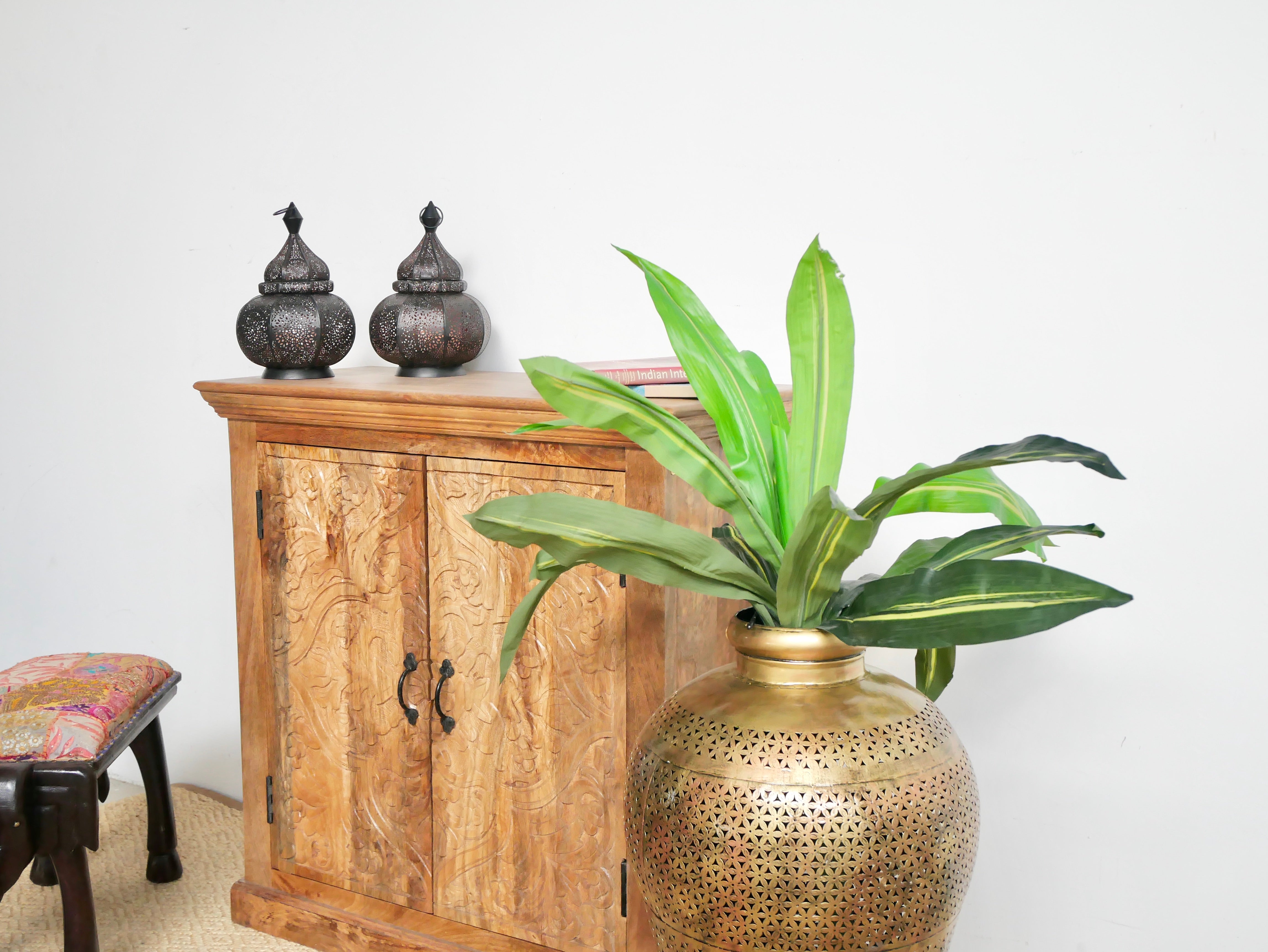 Side angle image of a carved wood furniture cabinet made from solid mango wood, hand-carved floral design, Mediterranean-style, 90 × 97 × 40 cm.