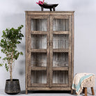 Handcrafted display cabinet made from reclaimed Teak wood with glass doors and Sanskrit motifs; sustainable and unique wooden furniture, 182 × 93 × 42 cm.