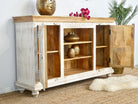 Side angle image of a carved mango wood console table with Indian motifs and natural finish; vintage furniture with 3 compartments and 2 drawers, 150 × 75 × 40 cm.