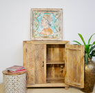 Open door image of a carved wood furniture cabinet made from solid mango wood, hand-carved floral design, Mediterranean-style, 90 × 97 × 40 cm.
