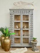Handcrafted mango wood cabinet with glass-panelled doors and internal storage – carved wood furniture made from sustainable mango wood with unique natural grain.