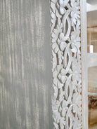 Close up image of a handcrafted mango wood cabinet with glass-panelled doors and internal storage – carved wood furniture made from sustainable mango wood with unique natural grain.