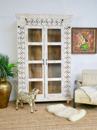 Handcrafted mango wood cabinet with glass-panelled doors and internal storage – carved wood furniture made from sustainable mango wood with unique natural grain.