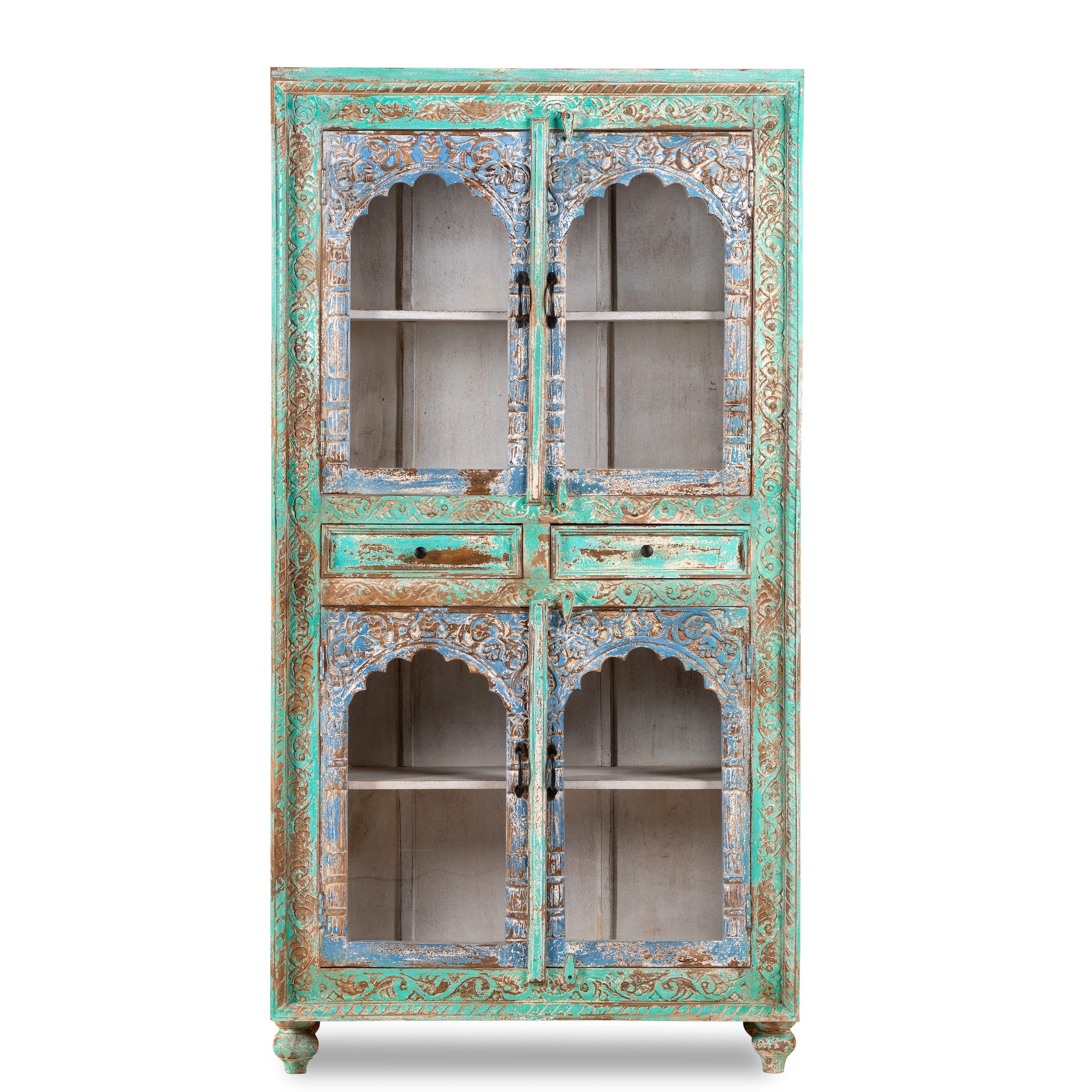 White background image of a hand-carved mango wood showcase with glass doors and drawers – carved wooden furniture in distressed turquoise and blue, combining artisan detail with vintage charm.