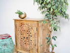 Side angle image of a carved wood furniture cabinet made from solid mango wood, Mediterranean-style with Indian floral carvings, 90 × 90 × 40 cm.