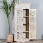 Side angle image with open door of  hand-carved mango wood wardrobe with whitewashed finish, bedroom furniture wooden wardrobe with floral and geometric lattice doors, 90 × 190 × 40 cm.