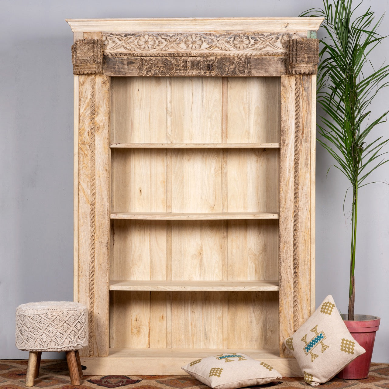 Lifestyle image of a hand-carved shelf made from reclaimed teak wood and mango wood, unique furniture with Ibiza-inspired finish, 150 × 208 × 52 cm.