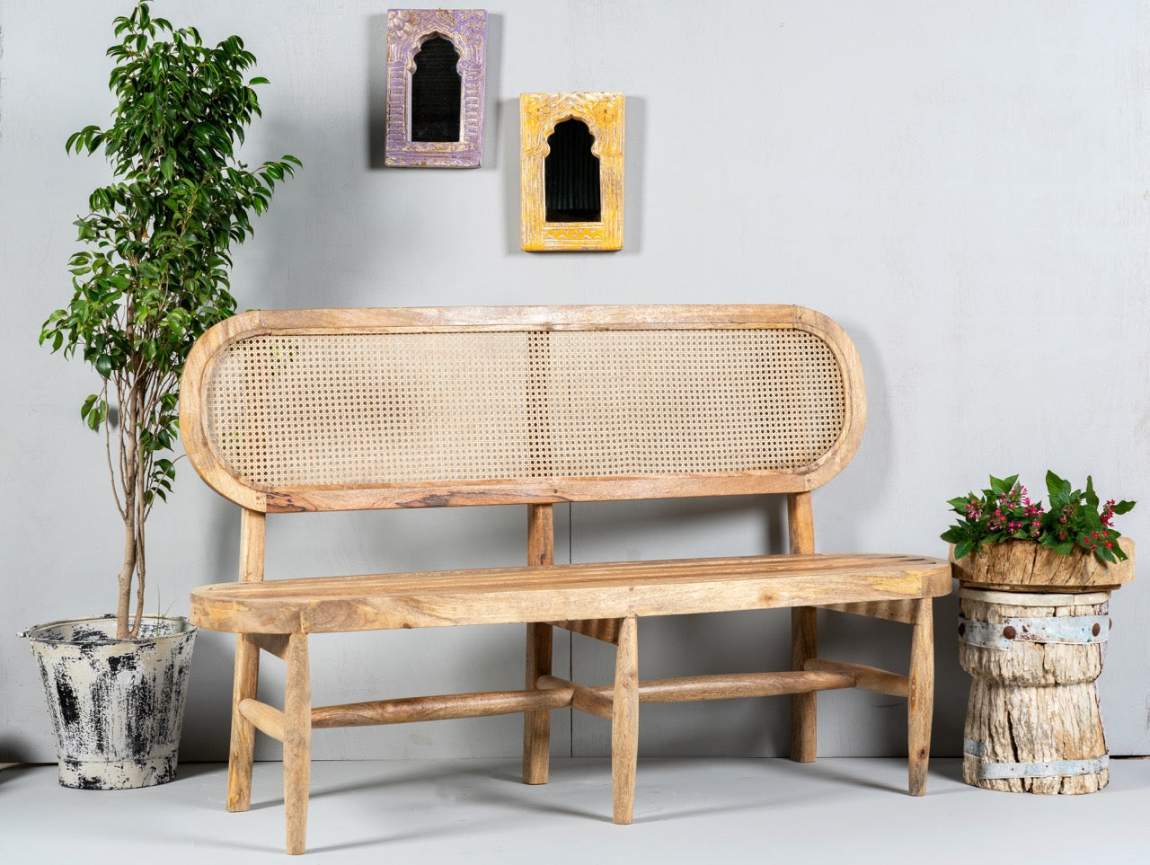 Side angle image of a mango wood bench with rattan backrest; handcrafted rattan furniture, 152 × 48 × 95 cm.