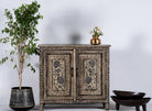 Lifestyle image of a hand-painted cupboard made from reclaimed wood with Indian floral motifs; ideal for boho chic living room or unique furniture decor, 100 × 92 × 36 cm.