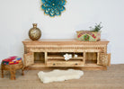 Open door image of a carved mango wood TV unit with hand-carved doors, one drawer, and open shelf, 150 × 60 × 40 cm.