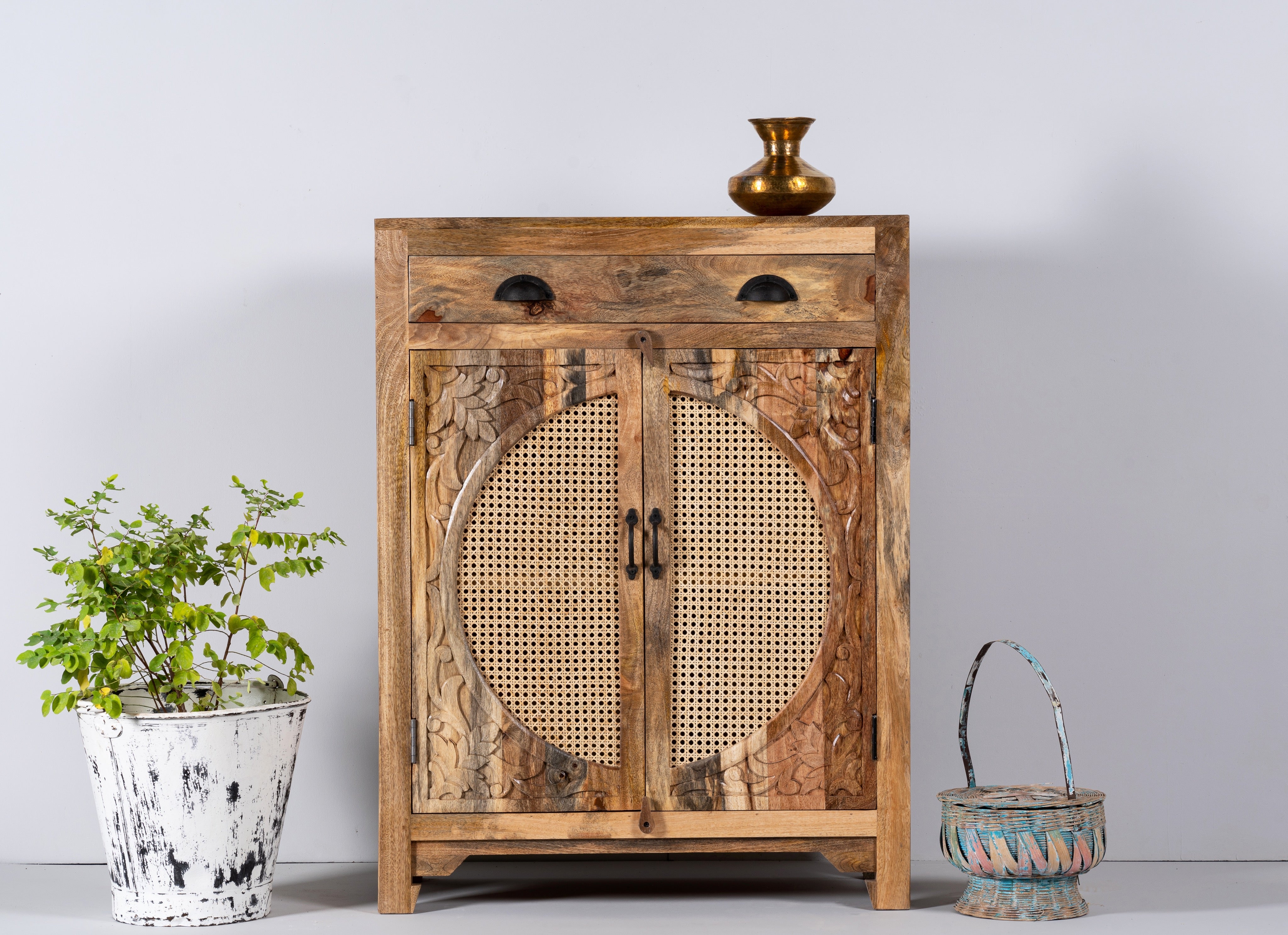 Natural Mango wood cupboard with rattan door panels and hand‑carved Indian ornamentation, 80 × 40 × 104 cm.